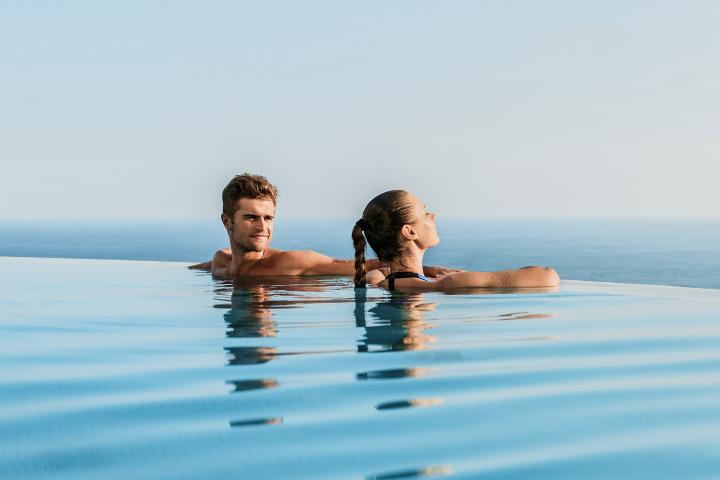 Jeune couple dans une piscine à débordement Bluefino