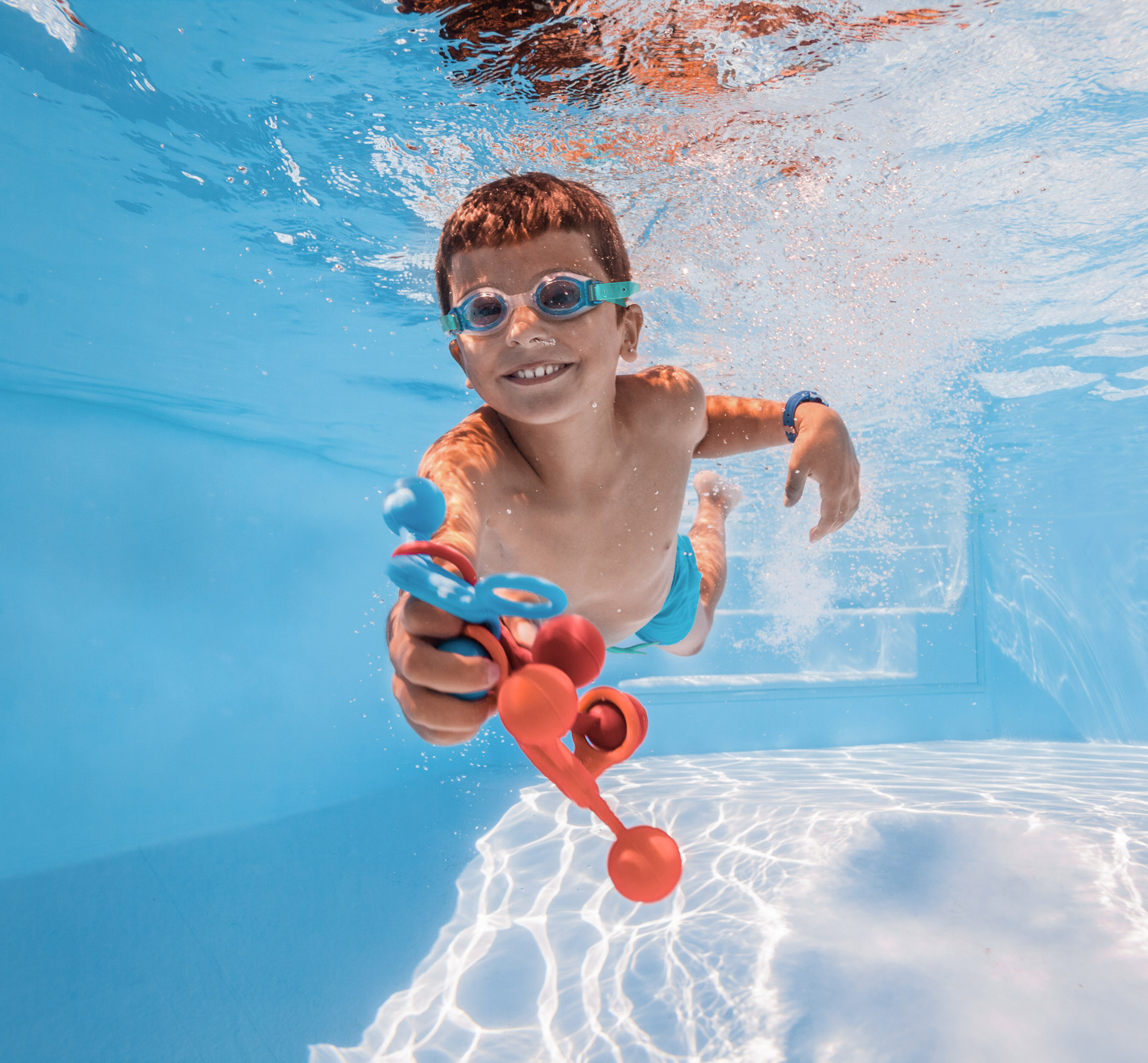 Kleiner Junge, der im Wasser eines Bluefino-Fertigpools spielt