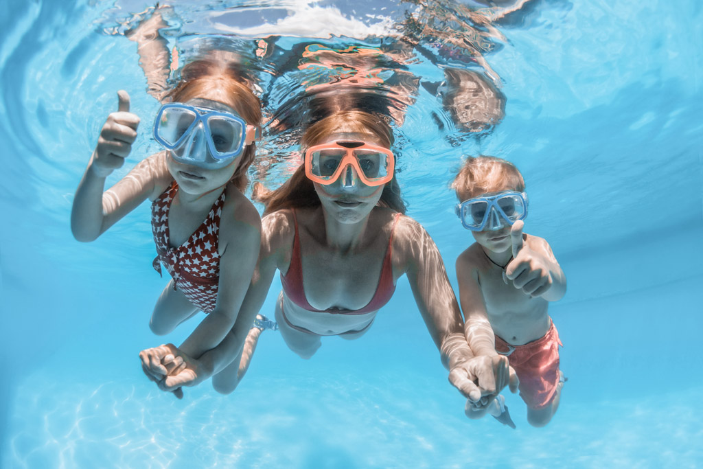 Een gezin met twee kinderen spelen onder water in een geprefabriceerd zwembad van Bluefino