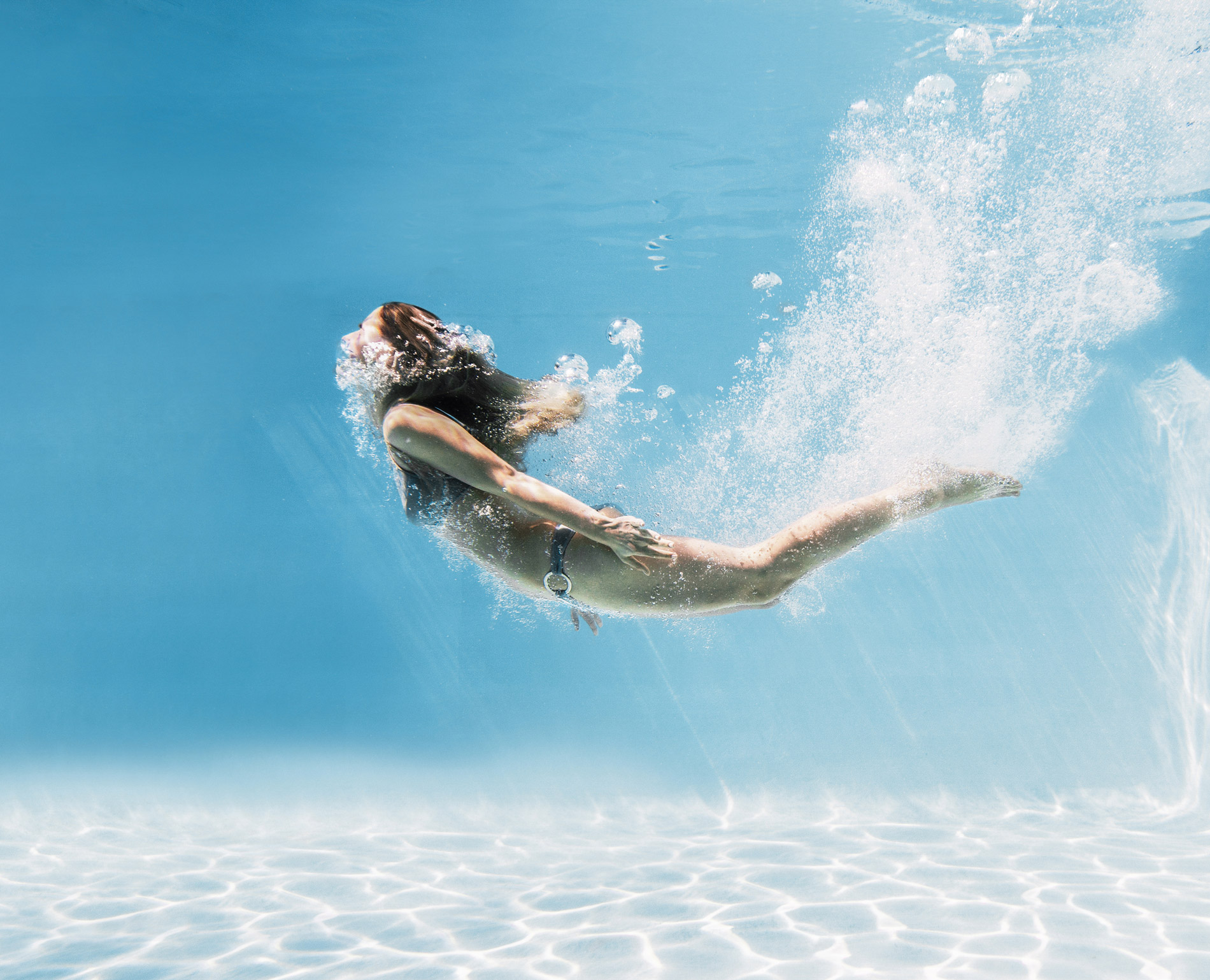 jeune femme qui plonge dans une piscine préfabriquée Bluefino