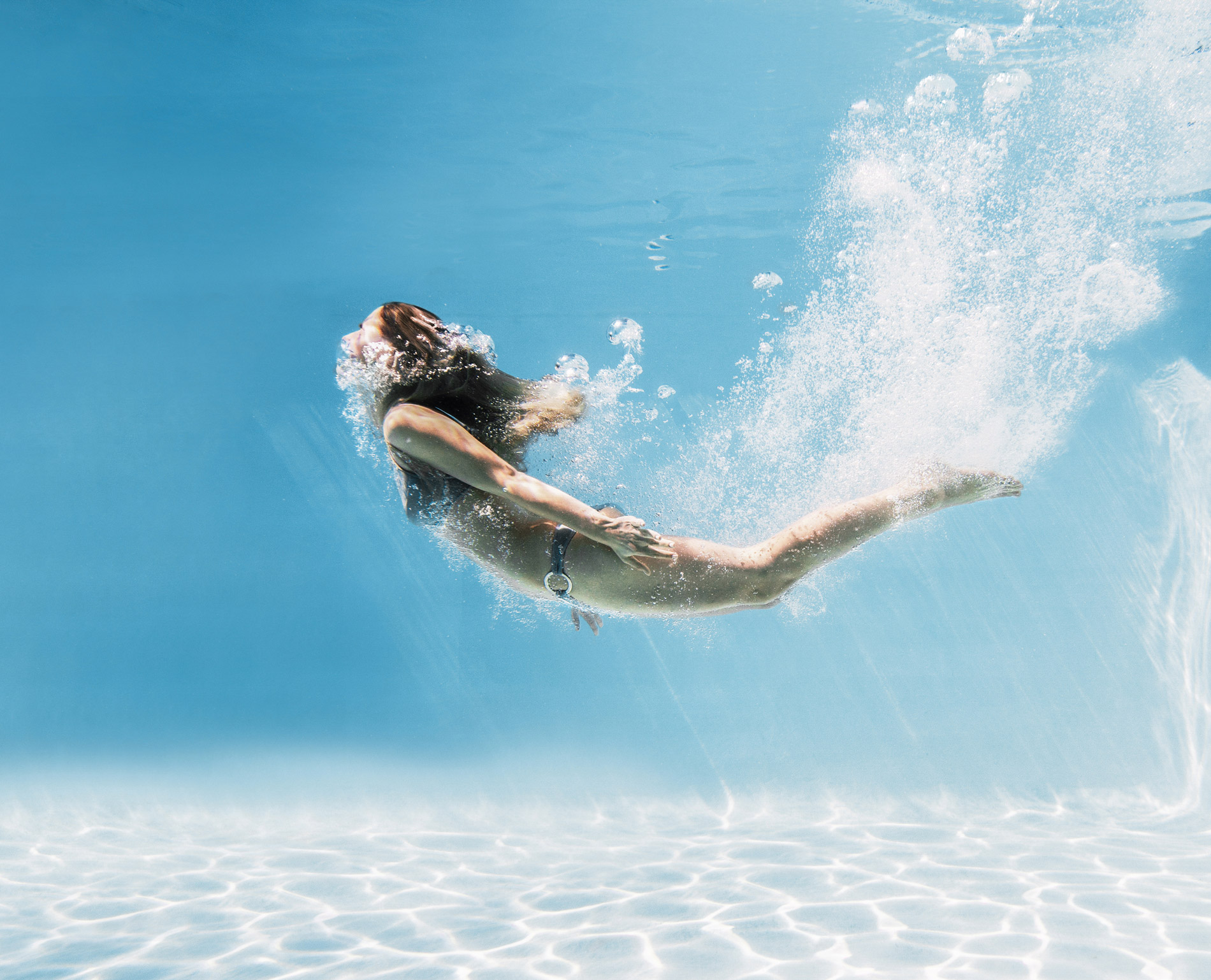 junge Frau, die in einen Bluefino-Fertigpool springt